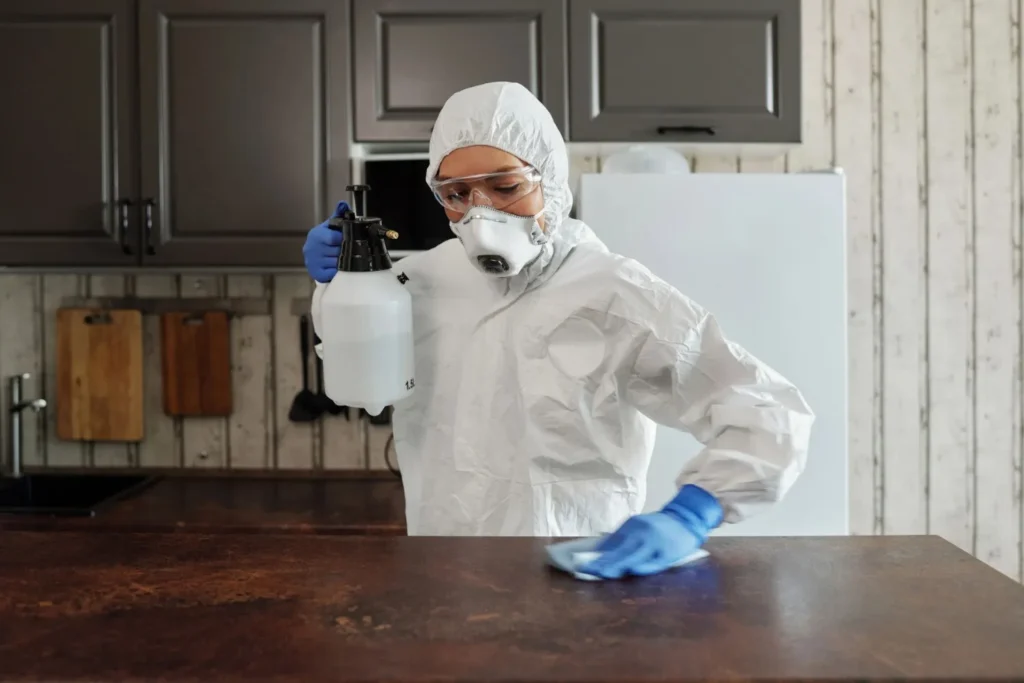 Person wiping a kitchen counter during weekly cleaning in West Concord, NC.