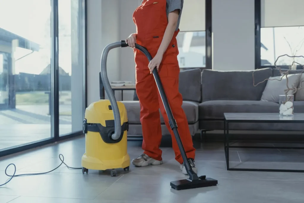 Vacuuming a living room rug during weekly home cleaning in West Concord, NC.