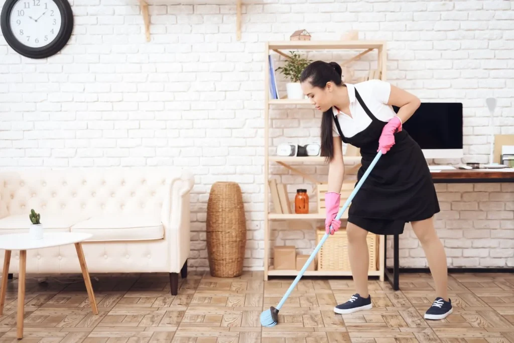Cleaner mopping a tiled floor beside an open shelf during move out cleaning in Myers Park, NC by Queen City Cleaners.